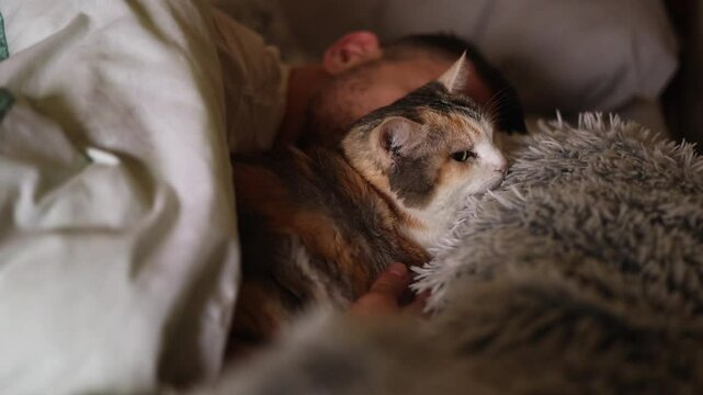 Young guy sleeps hugging a cat