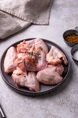 Raw chicken wings on black background.