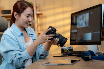 Fototapeta premium A young freelance woman is happily editing a video at home