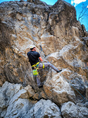  Young Girl Lead-Climbing on a Steep Rock Face: A Thrilling Ascent in the German Alps with Stunning Views and Rugged Limestone Formations