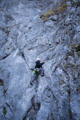 Obraz premium Man With Climbing Gear And Helmet On Toprope Route In Rocky Mountain Landscape Of Bavarian Alps