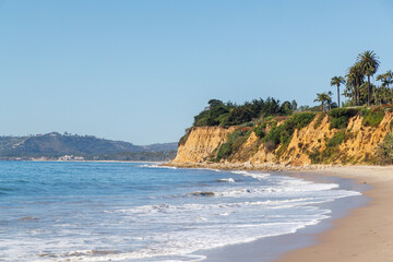 A breathtaking view of the California coast featuring golden sandy beaches, the vast blue ocean