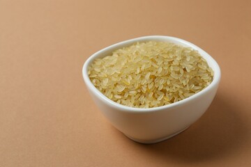 Raw brown rice in bowl on the table