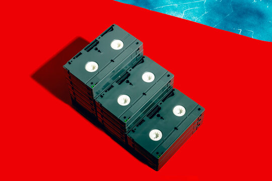 Stack of VHS cassettes on a red background with a blue accent