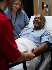 Touching hospital scene with a black African man. The family member is holding his hand gently. Focus on hand. Vertical layout