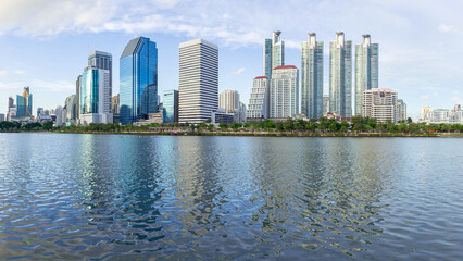 Obraz premium Modern Cityscape Skyline Reflected on Lake Water, Urban Architecture and Nature Harmony Concept