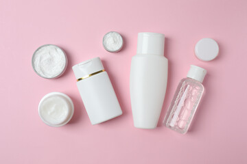 Natural cosmetic products on a pink background, top view