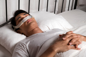Man sleeping peacefully with CPAP nasal mask, used for treating snoring and obstructive sleep apnea...