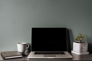 Minimalist workspace with laptop, coffee and notebook – calm home office setup, dark background