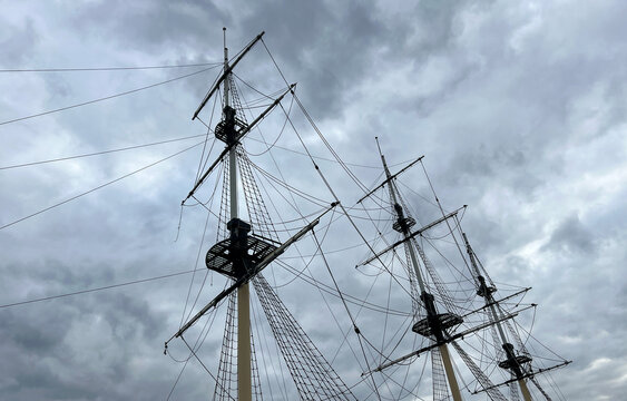 View of the ship's masts, platform and ropes, showing traditional marine details against a stormy sky. Photograph of the rigging of a vintage large sailboat. Marine rope ladder at ship.
