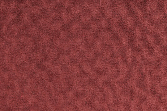 Faux fur, velours red fabric or cloth with wavy effect. Fluffy fabric of artificial fur textile material texture macro. Canvas background. Decorative fabric for curtain, upholstery and clothes.