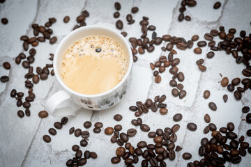 Top-down view of a delicious cup of coffee next to scattered coffee beans—perfect for café promotions, morning routines, and coffee lover content. Warm, inviting, and full of aroma.