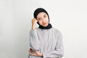 Stressed young Asian woman touching her head with a worried expression, showing signs of headache,...