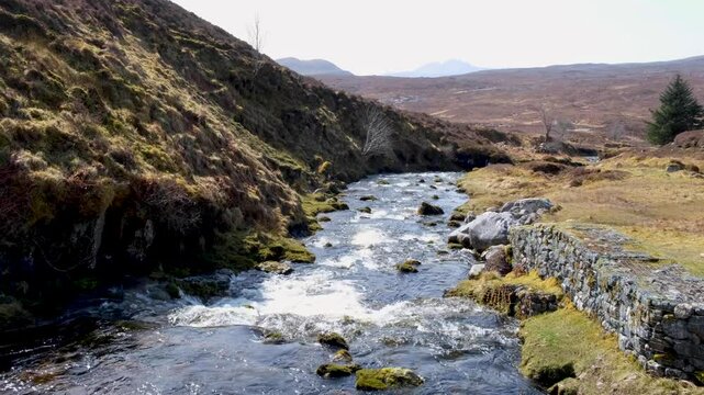 Scenic Scottish view of river in craggy rugged mountainous landscape of highlands in Scotland UK