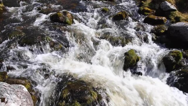 Fast flowing Scottish river with whitewash water over rocky terrain in Sutherlands highlands of Scotland UK