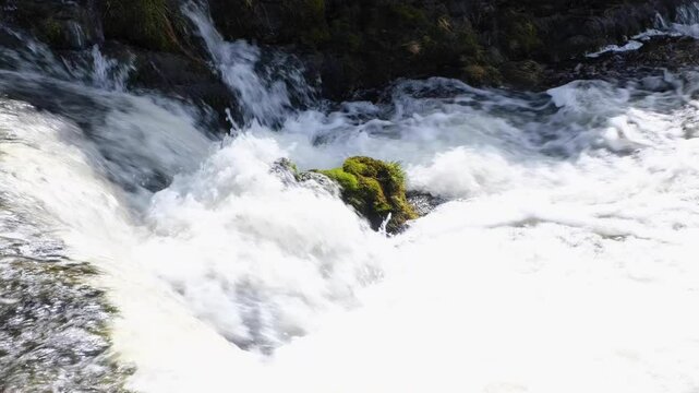 Closeup of fast flowing whitewash water of Scottish river stream brook in Sutherlands highlands of Scotland UK