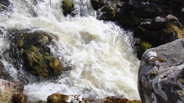 Closeup of Scottish river with fast flowing whitewash water in Sutherlands highlands of Scotland UK