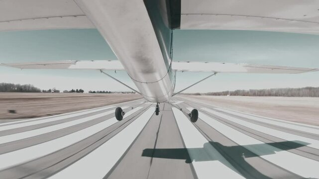 Cessna 150 performs precise centerline landing on a paved runway at a towered airport.