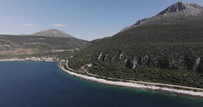 Aerial orbit of mountains surrounding the small coastal village of Limeni, Greece in the Peloponeese Mani Peninsula.