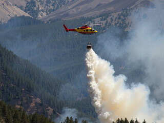 A helicopter with a water tank puts out a forest fire.
