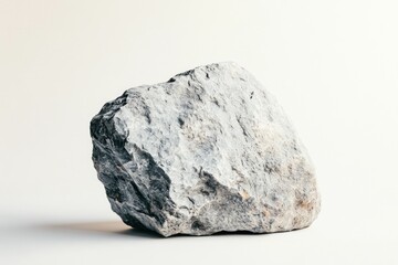 Fototapeta premium A large rock displays its rough texture and natural colors, highlighting its geological features against a clean white backdrop