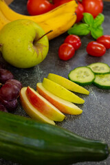 A composition of fresh fruits and vegetables on a black background. Healthy eating, vibrant colors, organic food, nutrition, vegan, and balanced diet.