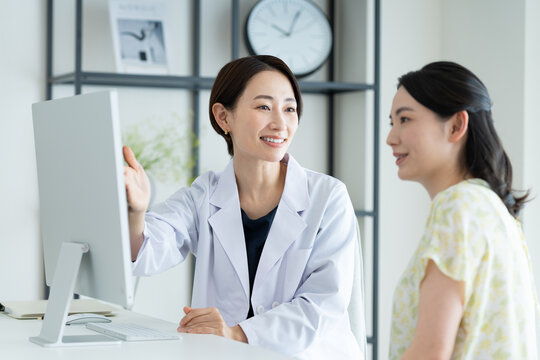 若い女性の診察をするミドルの医師