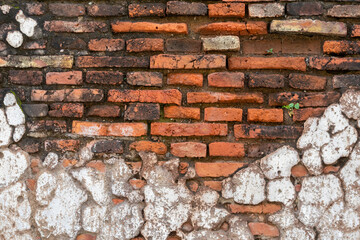 Weathered brick wall with peeling plaster, revealing layers of age and texture. Rustic charm and decay captured in a close-up shot.