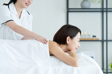 Obraz premium エステでマッサージを受けるミドルの女性