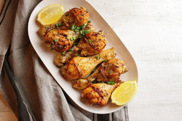  Grilled chicken. Spicy grilled chicken legs, drumsticks on the white plate. Top view.