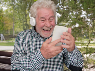 Happy Video Call. Heart-Warming Connections for a smiling senior bearded grandfather using smartphone to stay in touch with distant family or friend