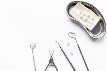 Dental steel instruments for dental prosthetics and oral treatment on a white background. Dentist desk top view