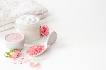 Closeup of pink roses essence skin care cream with flowers and petals