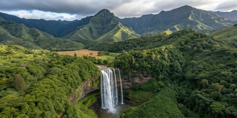 Majestic tropical waterfall cascades through lush jungle, towering mountains framing a serene aerial paradise.