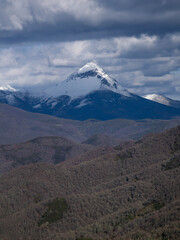 Imposing mountain peak covered with snow on a cloudy day