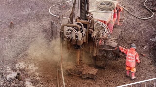 Aerial viea of drilling equipment piling rig in action emitting steam as its shaft rotating