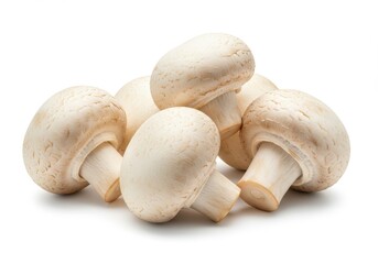 A group of fresh white button mushrooms piled together on a plain white surface in bright studio lighting isolated on white background