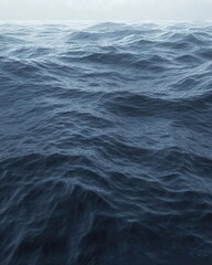 Fototapeta premium Tranquil expanse of deep blue ocean waves under a misty sky creating a serene and calming atmosphere perfect for backgrounds