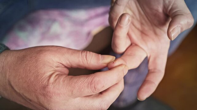 Diabetic Pricks Finger and Uses Blood Glucose Monitor for Self-Care CLOSE-UP
