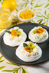 Lemon Curd and Berries Pavlova dessert on light colorful background. Vertical