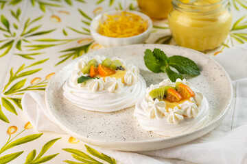 Delicious Mini Pavlovas topped with Fresh Fruit and Cream for dessert on colorful background