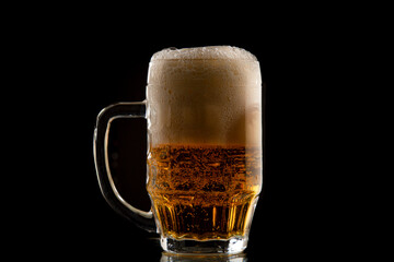 Half a litre of beer on black background. A glass of Pilsner beer