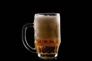 Half a litre of beer on black background. A glass of Pilsner beer