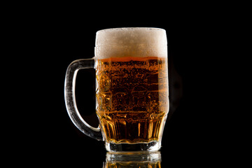 Half a litre of beer on black background. A glass of Pilsner beer