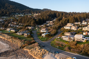 Aerial drone picture of Manzanita on the Oregon Coast ,at the Pacific Ocean, small coastal town during sunset, sandy shoreline, forested mountains. Perfect for travel and tourism themes © Hrach