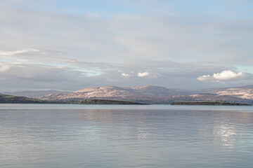 Calm clear water surface with the shore in the background