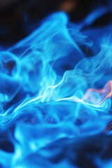 Obraz premium Captivating close up of vivid blue flames dancing above dark surface creating abstract ethereal patterns and mesmerizing visual effect