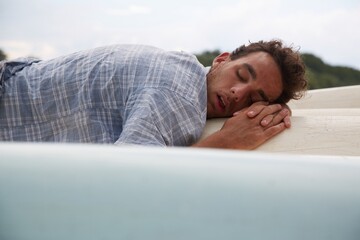 Man sleeping on the bottom of canoes