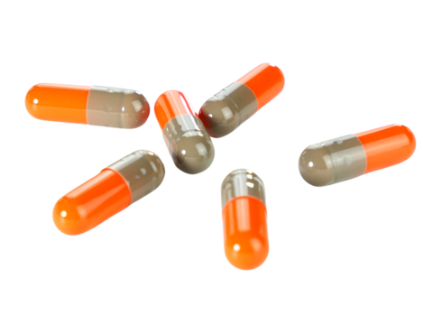 Bulk orange capsule pills isolated on white background.