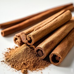 Arrangement of cinnamon sticks and ground spice isolated on white background